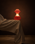 volara max-red glass button control rechargeable table lamp switched on with a warm ambient glow